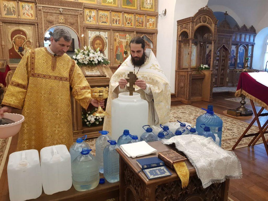 Священник освящает воду